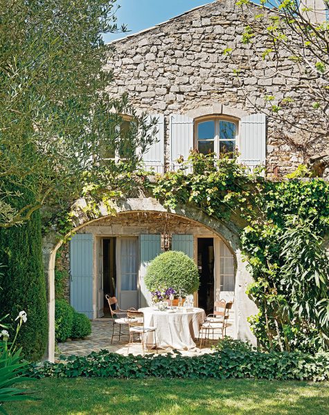 fachada de piedra de casa rustica con mesa y sillas junto al arco 1013x1280 475x600 - La Ferme du Bon Dieu: Una granja convertida en casa que alberga una historia de amor