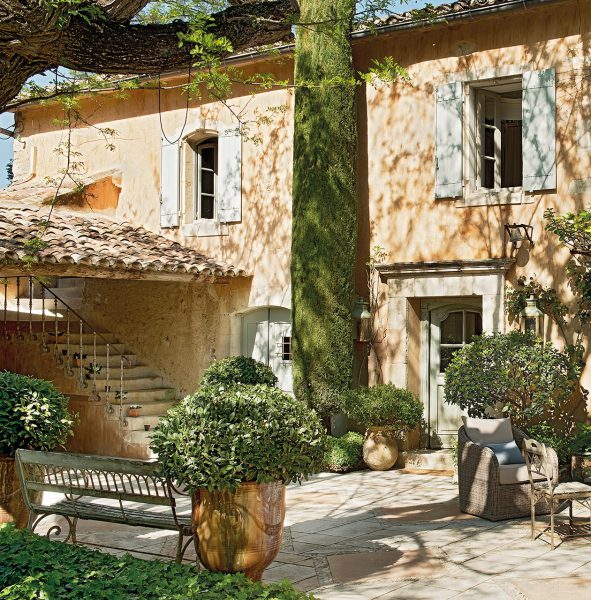 patio con cipres y porche con banco de hierro 1260x1280 1 591x600 - La Ferme du Bon Dieu: Una granja convertida en casa que alberga una historia de amor